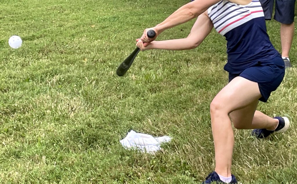 Adult swinging a bat